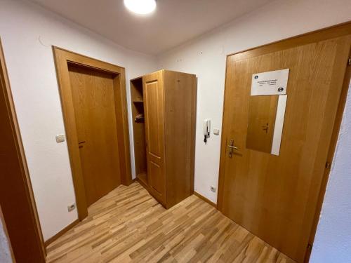 a room with two doors and a hallway with wooden floors at Haus Monika in Kirchberg in Tirol