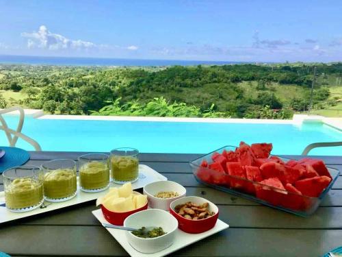 a table with a tray of watermelons and other food at Villa Vertigo in Río San Juan