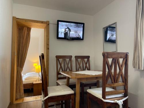 a room with a table and chairs and a television on the wall at Haus Monika in Kirchberg in Tirol