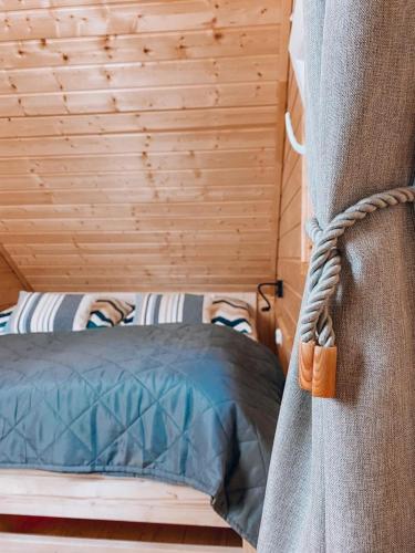 a bed in a room with a wooden wall at W Starym Sadzie in Wünschelburg