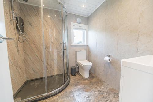 a bathroom with a shower and a toilet at North Lodge Cartmel in Cartmel