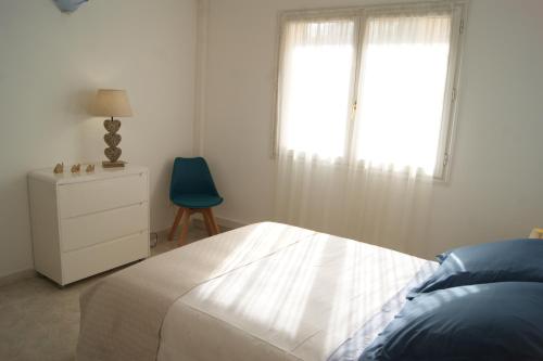 1 dormitorio con 1 cama, 1 silla y 1 ventana en Vue sur mer - Appartement Les Pins, 