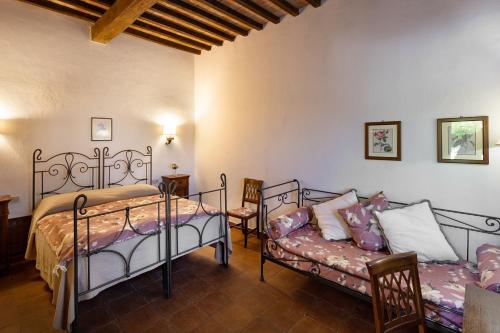 a bedroom with two beds and a couch at Il Poggio degli Olivi in Bettona