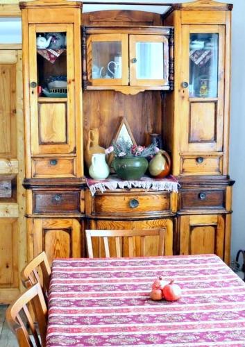 a dining room with a table and a wooden hutch at Pottery House Sanahin in Alaverdi