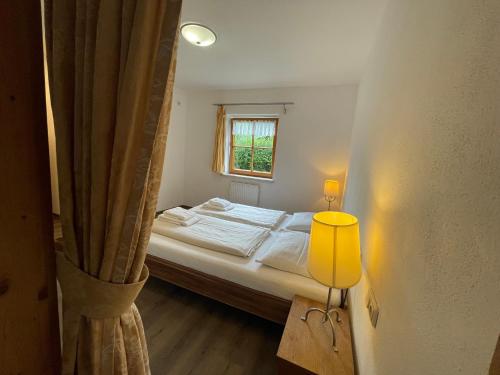 a small bedroom with a bed and a window at Haus Monika in Kirchberg in Tirol