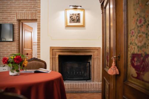 a room with a fireplace and a table with a red table cloth at Il Poggio degli Olivi in Bettona