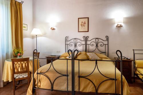 a bedroom with a bed and a table and chairs at Il Poggio degli Olivi in Bettona