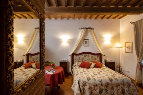 een slaapkamer met 2 bedden en een tafel bij Il Poggio degli Olivi in Bettona