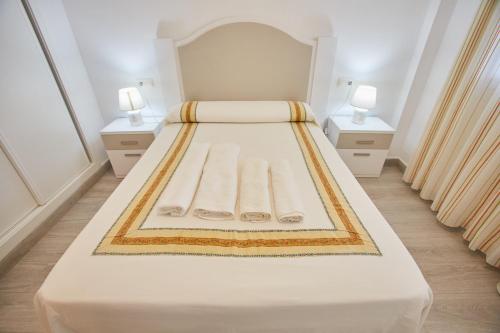 biała sypialnia z 2 łóżkami i 2 stolikami nocnymi w obiekcie VistAzul 401 w mieście La Antilla