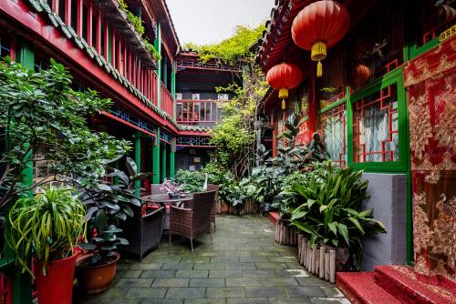 un patio de un edificio con plantas y faroles en Beijing Double Happiness Courtyard Hotel, en Beijing