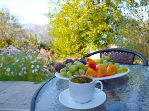 einen Obstteller und eine Tasse Kaffee auf dem Tisch in der Unterkunft Pottery House Sanahin in Alawerdi