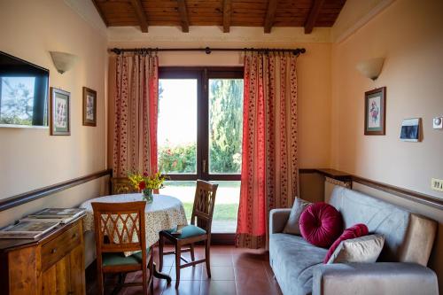 a living room with a couch and a table and a window at Il Poggio degli Olivi in Bettona