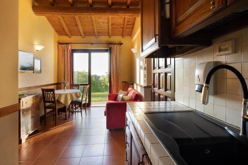 a kitchen with a person sitting in a chair in a room at Il Poggio degli Olivi in Bettona