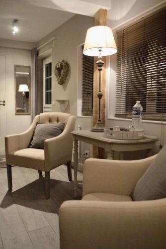 a living room with a chair and a table and a lamp at Le Paddock - Chambres et table d'hôtes in Le Déluge