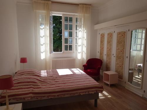 um quarto com uma cama, uma cadeira e uma janela em Villa sur la corniche vue mer em Concarneau