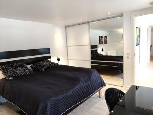 a bedroom with a large black bed and a mirror at Værelser i midtbyen in Herning