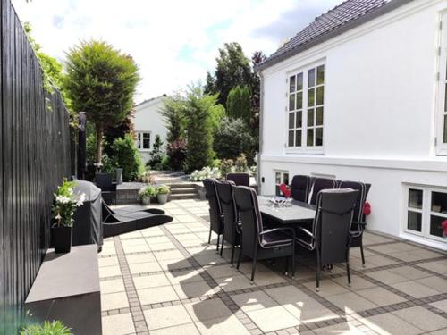 a patio with a table and chairs and a building at Værelser i midtbyen in Herning