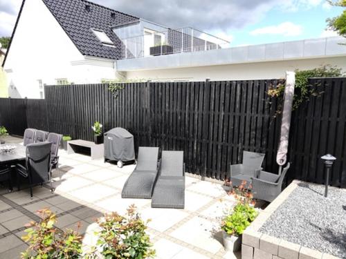 a patio with chairs and a table and a fence at Værelser i midtbyen in Herning