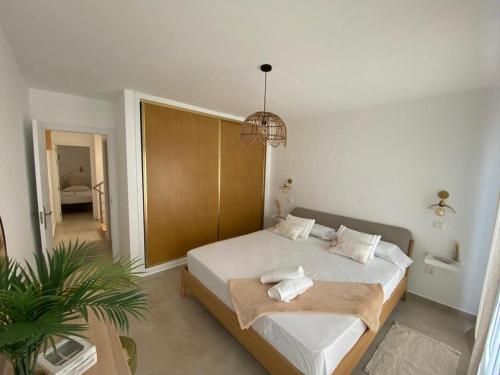 a bedroom with a large bed and a potted plant at AmuraHouse. Private terrace BBQ. Centric and cosy. in Cotillo