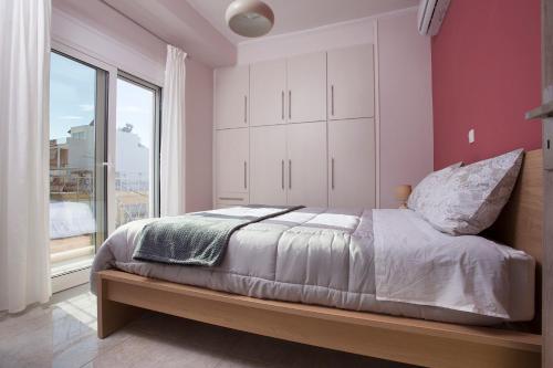 sypialnia z łóżkiem i dużym oknem w obiekcie Διαμερίσματα στο Δυτικό Μοσχάτο w Pireusie