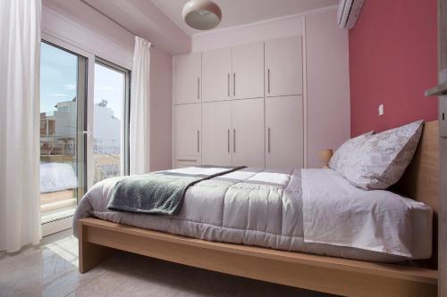 una camera da letto con un letto e una grande finestra di Διαμερίσματα στο Δυτικό Μοσχάτο a Pireo