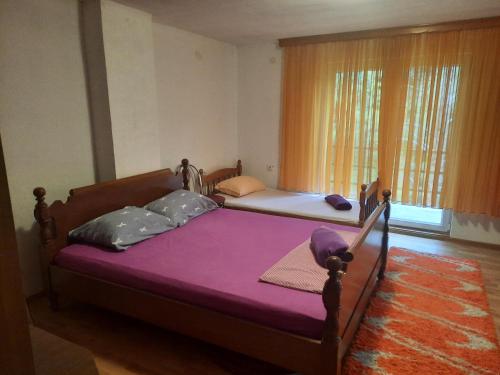 1 dormitorio con 2 camas con sábanas moradas y ventana en Vikendica krivaja Ribnica-Odmor na Krivaji, en Zavidovići