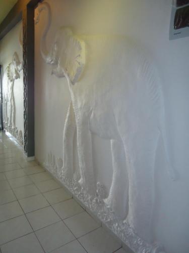 a white elephant carved into the side of a wall at Whitepearl Beach in Hikkaduwa
