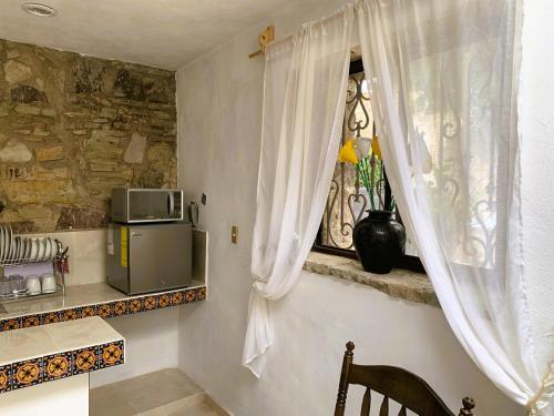 グアナファトにあるNoria House in Exhacienda La Escaleraの窓、テーブル、電子レンジ付きのキッチンが備わります。