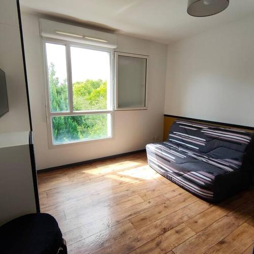 un salon avec un canapé et une fenêtre dans l'établissement Studio Emotion 4P - Train station 200m - Disneyland Paris 5 min, à Montévrain