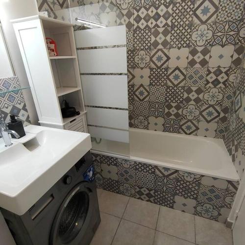 une salle de bain avec une machine à laver et un lavabo dans l'établissement Studio Emotion 4P - Train station 200m - Disneyland Paris 5 min, à Montévrain