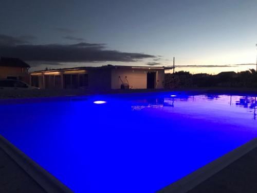 a swimming pool with blue lighting in front of a house at L'Escale au Portugal Villa-B&B-Spa in Ataíja de Baixo