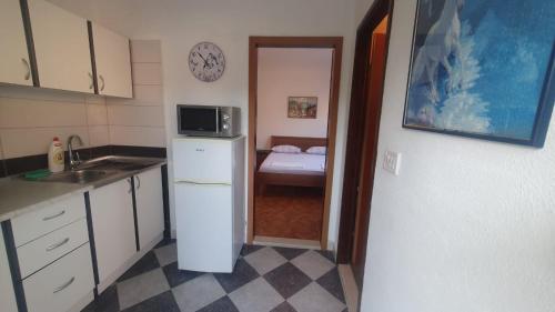 a kitchen with a refrigerator and a bed in a room at Sunny place in Trpanj