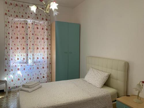 a bedroom with a bed with a green cabinet and a window at Sea Life House in Alghero