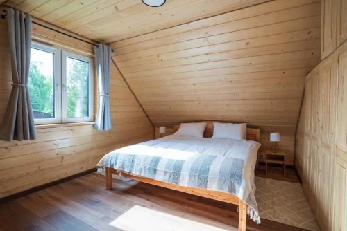 a bedroom in a log cabin with a bed at Roztoczańska Ostoja in AdamÃ³w