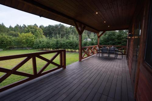 a large wooden deck with a table and chairs on it at Roztoczańska Ostoja in AdamÃ³w