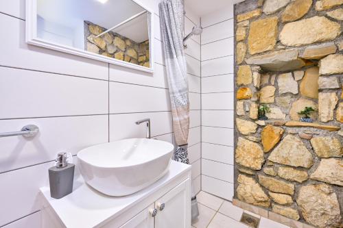 a bathroom with a sink and a stone wall at Greta Rest House in Sopot