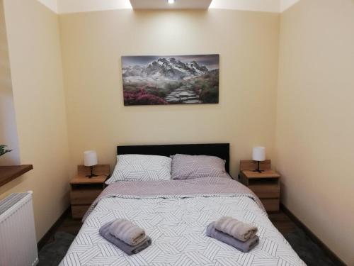 a bedroom with a bed with two towels on it at Apartament Shadow in Białystok