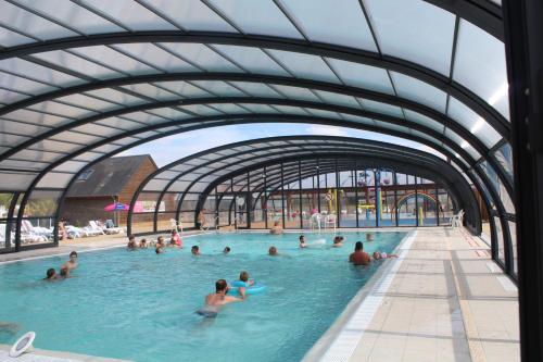 un groupe de personnes nageant dans une piscine dans l'établissement La nature en famille, à Litteau