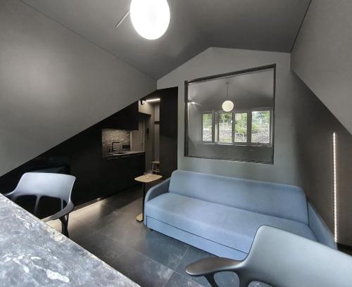 uma sala de estar com um sofá azul e uma janela em Modern studio in bohemian Uzupis, Vilnius em Vilnius