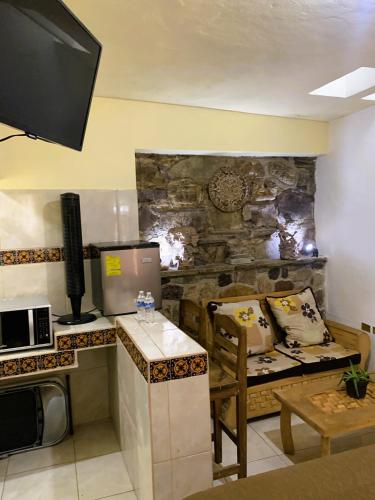 a living room with a table and a kitchen with a couch at La Capelina Apartment in ExHacienda la Escalera in Guanajuato