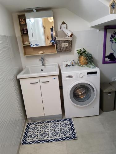 een badkamer met een wasmachine en een wastafel bij Appartamenti Bellavista 107 in Chioggia