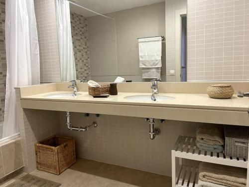ein Badezimmer mit zwei Waschbecken und einem großen Spiegel in der Unterkunft Vivienda adosada en Castillo, Caleta de Fuste in Caleta de Fuste