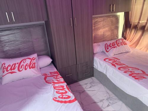 2 almohadas de coca cola en 2 camas en una habitación en بورتو سعيد Portosaid en Port Said