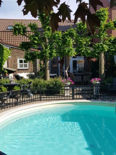 een zwembad voor een huis bij B&B Le Jardin in Neerpelt