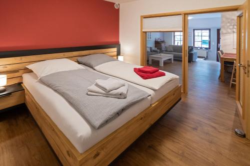 1 cama grande de madera con 2 toallas en Gulfhof Alt-Addenhausen, en Neuharlingersiel