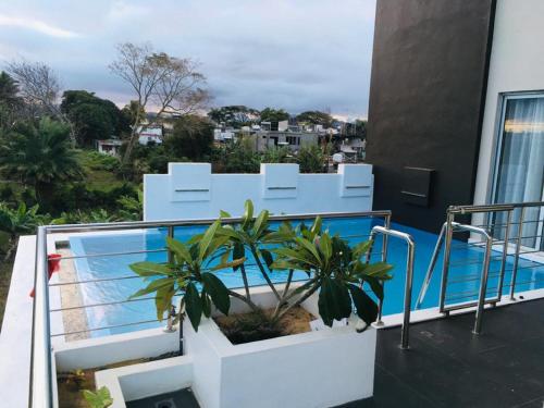 einen Balkon mit Pool auf einem Gebäude in der Unterkunft ISLAND RESIDENCE Plaisance - Mauritius - 15718 in Plaine Magnien