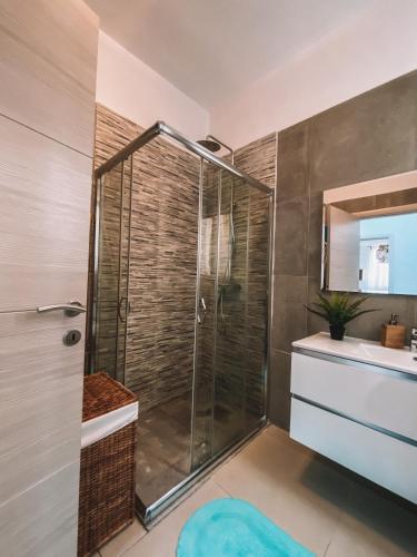a bathroom with a shower with a sink and a mirror at Exclusive Paceville NEW 3 bedrooms apartment in St. Julianʼs