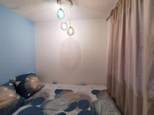 - une chambre avec un lit avec un rideau et une lumière dans l'établissement Superbe appartement Cap d'Agde, au Cap d'Agde