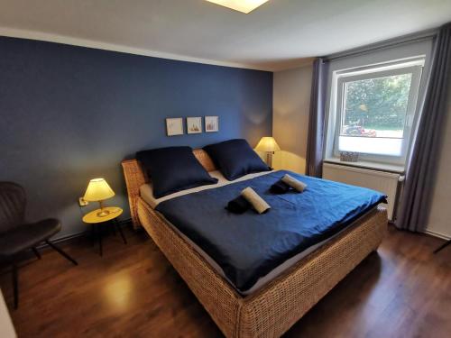 een slaapkamer met een bed met blauwe lakens en een raam bij 07 Birkenhain in Parchtitz
