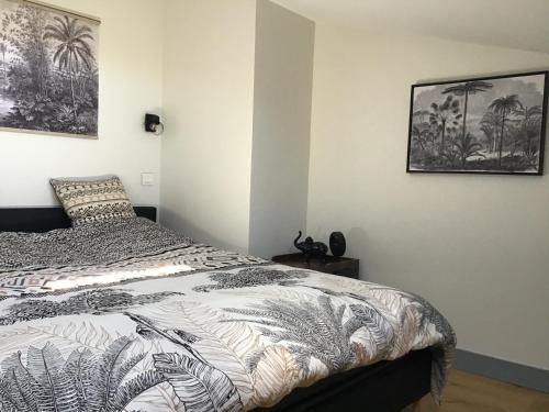 - une chambre avec un lit et deux photos sur le mur dans l'établissement Appart Christelle, à La Rochelle